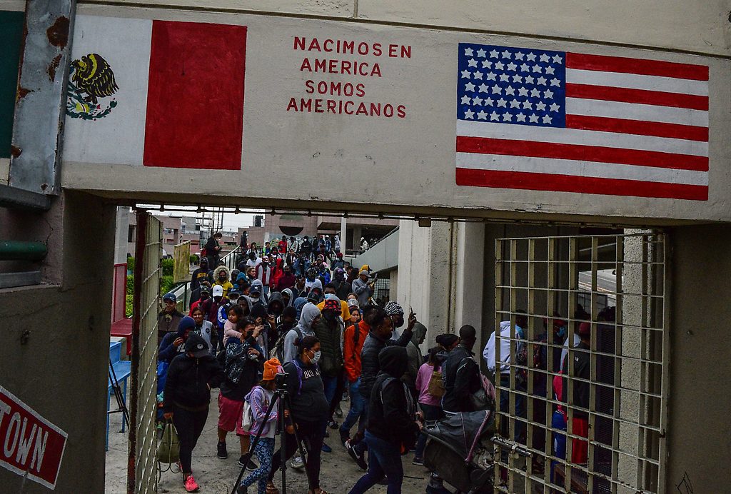 Migrantes, de origen haitiano, buscan información en el albergue sobre la extension del Titulo 42 en Tijuana, en Baja California