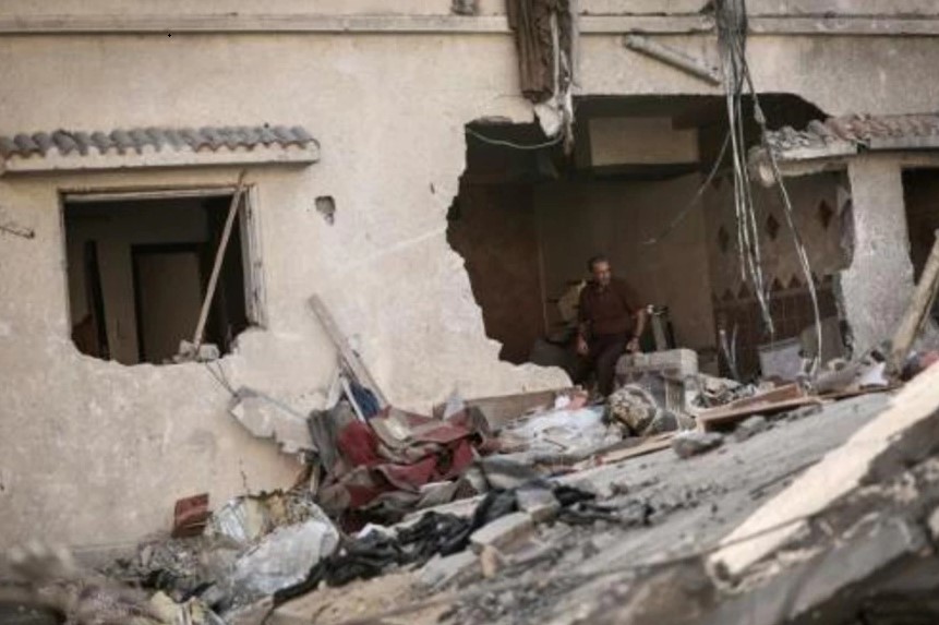 Un palestino, sentado entre los escombros de su destruida casa