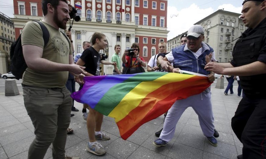 Manifestantes anti-gay intentan romper una bandera arcoiris durante una manifestación LGBT en el centro de Moscú