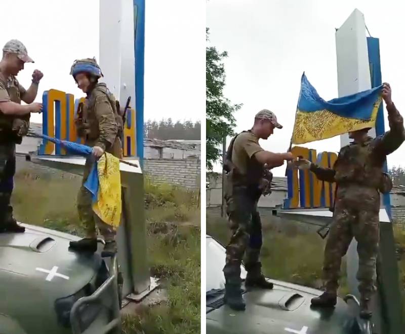 Dos soldados ucranianos colocan la bandera de Ucrania tras recuperar la ciudad de Limán, en Donetsk