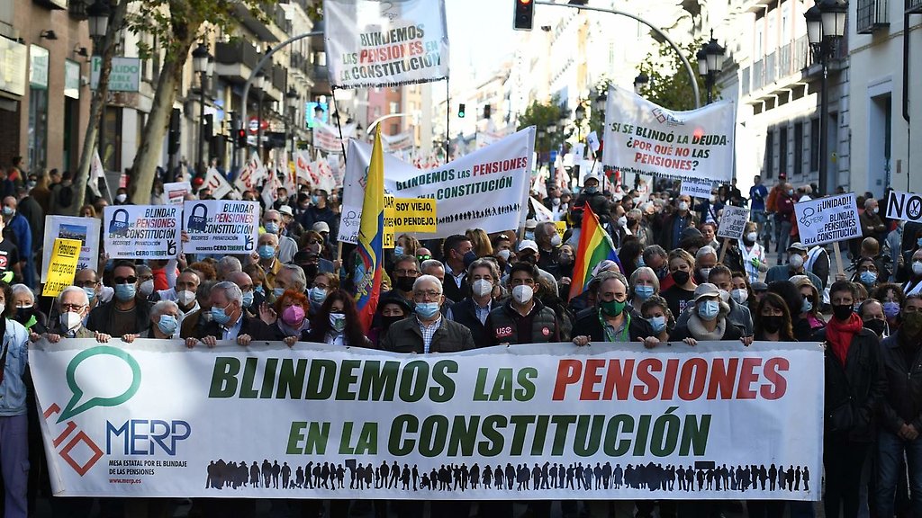 Un grupo de personas con pancartas durante una manifestación que reclama el blindaje de las pensiones en la Constitución