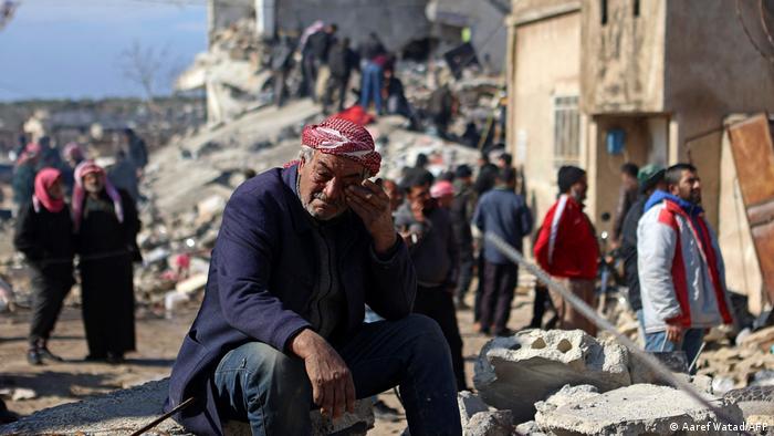 Un sirio sentado ante las ruinas de su casa en la ciudad de Jandaris