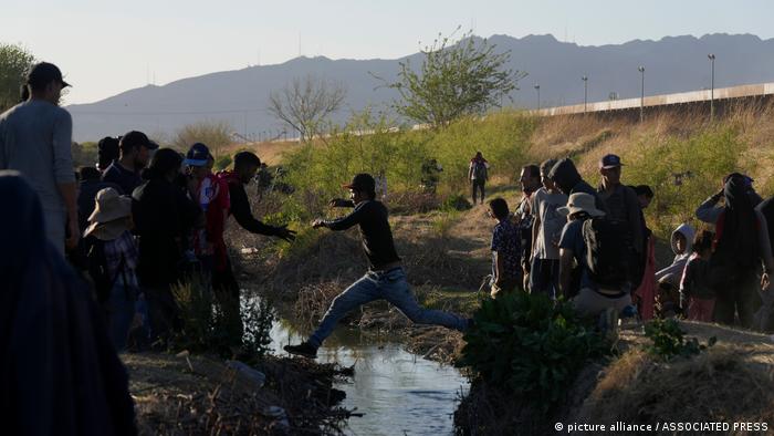 Migrantes saltan de un lado a otro del río Bravo hacia Estados Unidos desde Ciudad Juarez, zona donde el caudal es apenas un riachuelo