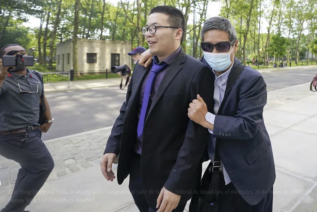 Zhu Yong (derecha) trata de evadir a los fotógrafos al salir de la corte federal de Brooklyn, el miércoles 31 de mayo de 2023, en Nueva York.