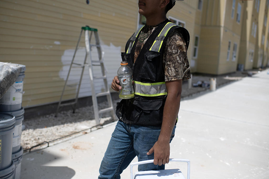 Un trabajador de la construcción toma una bebida hidratante durante una ola de calor en Houston, Texas