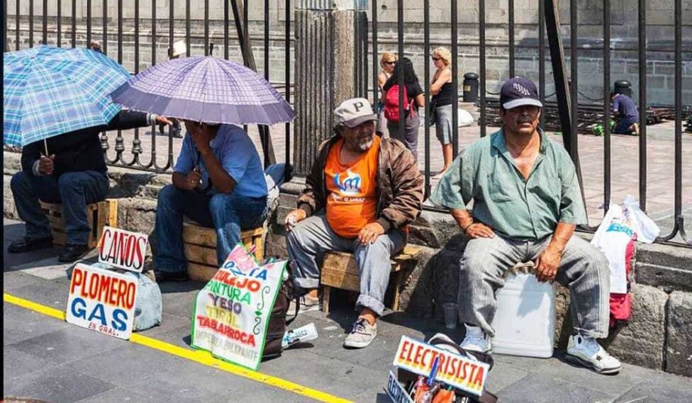 Trabajadores informales mexicanos ofrecen sus servicios en una vía pública