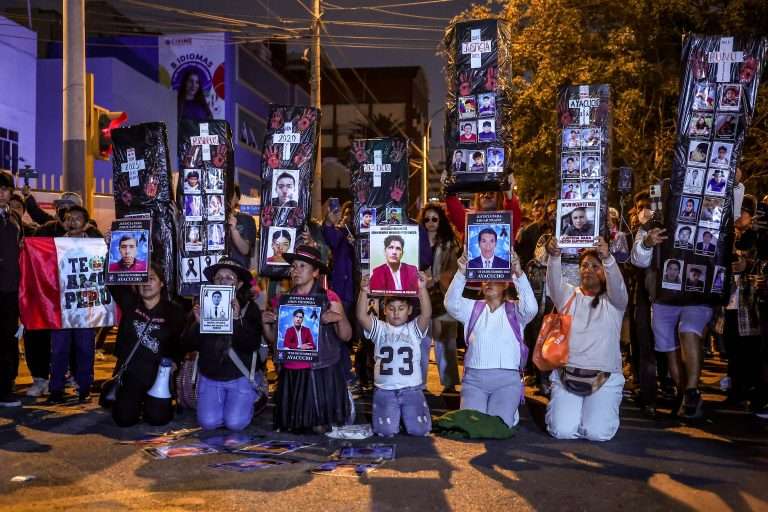Manifestantes con rostros de asesinados por la represión en Perú