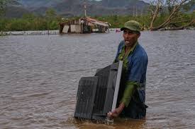 Un cubano carga con su televisor en medio de las inundaciones ocasionadas por Melissa